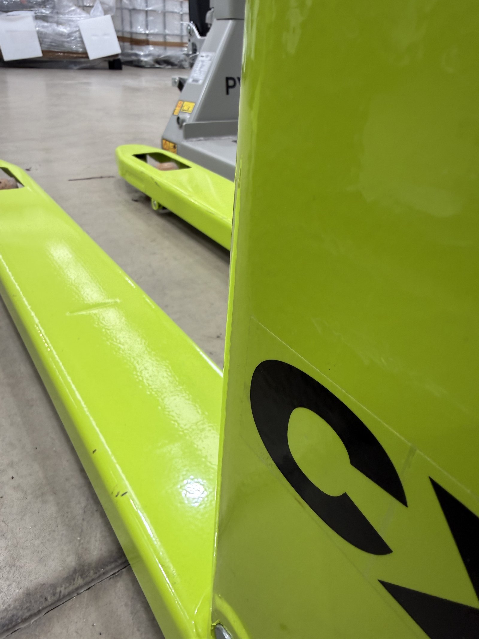 Industrial pallet truck with reinforced steel forks